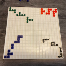 Load image into Gallery viewer, The Blockus board with the 3d printed tiles laid out on it. Each color has a different shape for tactile discrimination. The pieces are linked together into different shapes. 
