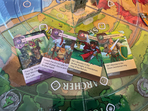 A selection of four cards laid out on the board. Tar, Scavenger, a red hero and a green swordsman. The braille has all the information needed to play the cards on it