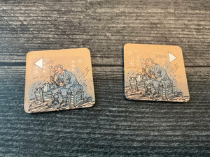 Two support tokens with braille on them