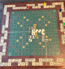 Load image into Gallery viewer, The Double Double Domino Board, which resembles a scrabble board, with a transparent overlay on it. 3d printed replacement pieces are along the sides and the board has dominoes on it.
