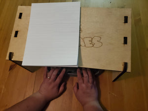 braille sheet being read on the table with the perkins under it