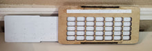 Load image into Gallery viewer, A white thermoformed sheet slides within a wooden base. The wooden base is 7 days across. The thermoformed sheet can be felt through the holes so that the correct dates are shown on the calendar.
