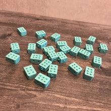 Load image into Gallery viewer, A wide shot showing a pile of the snap blocks. Exagerated braille is on the top of the blocks, regular sized braille is to the front and pegs/holes are on the sides of the pieces so they can fit together in a line.
