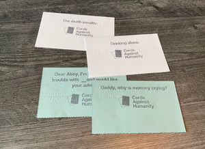 A close up on the index cards, both the blue prompt cards and the white response cards. All cards have print and braille on them