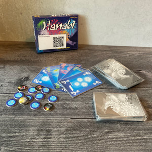 Hanabi laid out. The cards have transparent braille on them and the fuse tokens have braille on them as well.