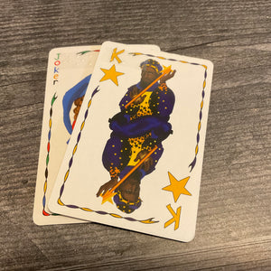 A close up of a joker and a king card with braille on them.