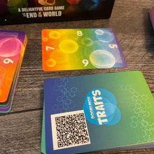 Load image into Gallery viewer, A close up on the gene pool cards. They have braille on each edge. The part facing away from the user is &#39;upright&#39; and players rotate the card as they gain or lose their gene pool just like print players do. A pile of trait cards is in the foreground with a QR code. Although the text of the card is in braille on the cards, sometimes it is reworded to fit on the card. The QR code has the full text of the card in the original wording.
