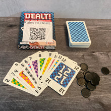 Load image into Gallery viewer, Dealt box with cards face up. The cards have transparent braille stickers on all of them from the accessibility kit. Black chips from the game are in the corner.

