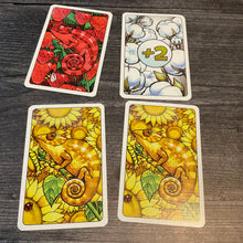 Load image into Gallery viewer, Close up on 2 yellow, a red and a +2 card, all with transparent braille on them

