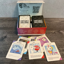 Load image into Gallery viewer, The box for unstable unicorn with 6 cards in front of it. The cards have transparent braille on them. The baby cards have transparent braille on both sides.
