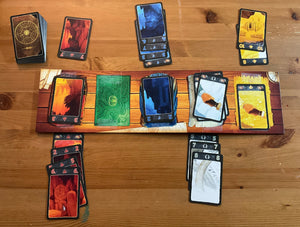 A picture of the game and the board laid out. Braille stickers are on all of the cards and the board. The board is two sided and the 5 expedition side is shown.
