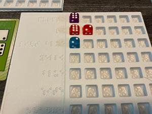 A close up on the trays. There are 6 slots for dice in each row. The main game only supports 4 players, but 8 can play if you have both red and purple.