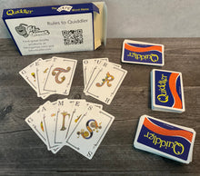 Load image into Gallery viewer, Cards laid out with transparent braille on them. The words &quot;Get&quot; &quot;our&quot; &quot;games&quot; are spelled out with the cards.

