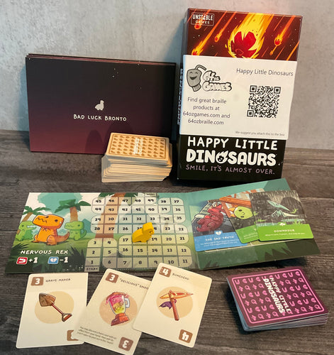 A shot showing the two types of cards, the box and the tactile player boards.