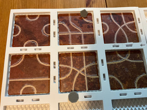 A close up on the tiles and the 3d pieces. The tactile transparent stickers on the tiles can be seen. The tiles are firmly in the board's slots so they do not move around