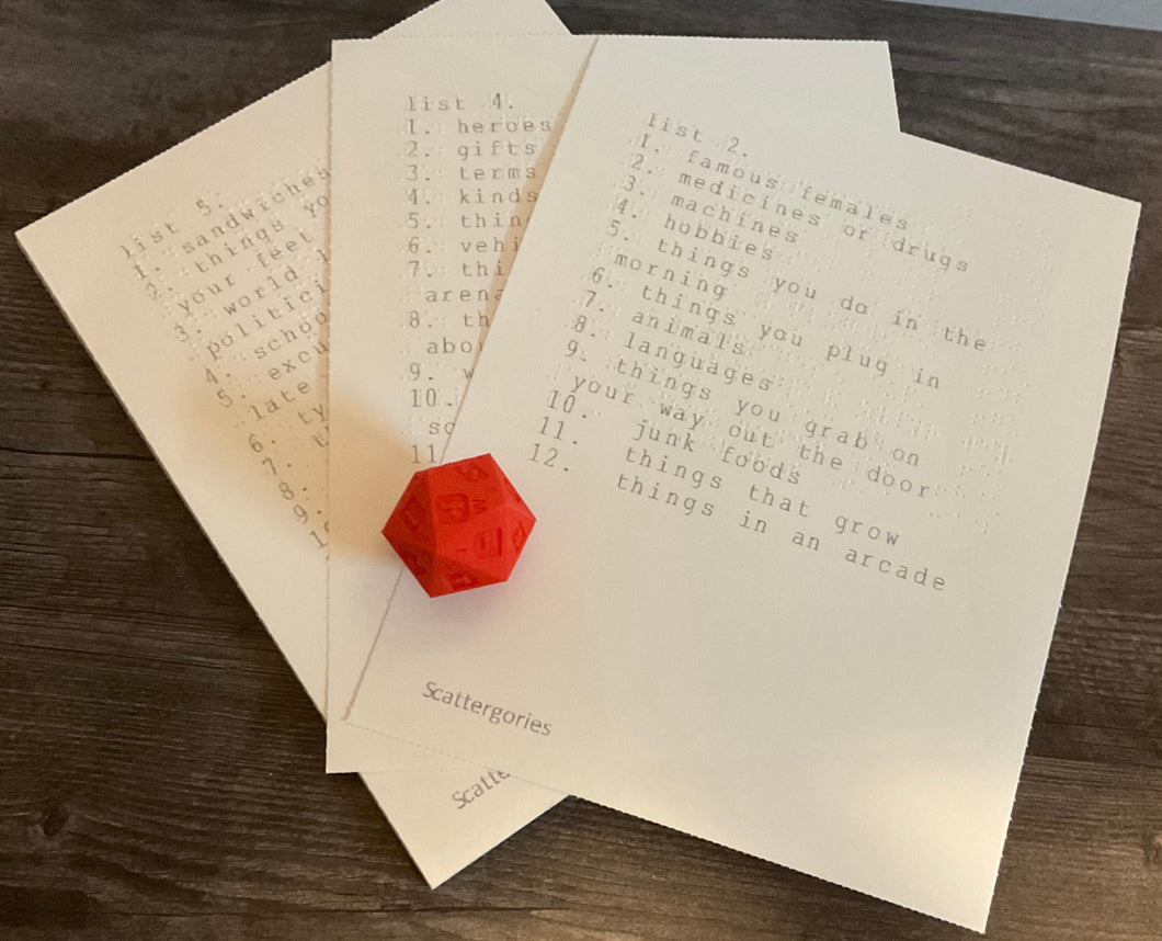 The 3d printed replacement 20 sided-die with letters on it along with the lists. All lists are in both large print and braille.
