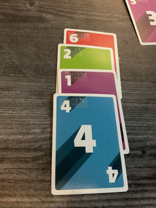 4 cards setup in a row. They all have different numbers and colors as the rules say you must