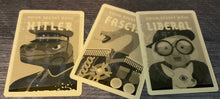 Load image into Gallery viewer, The role cards. They all have tactile shapes on them. The Hitler has a swastika, the fascist has an x on it, and the liberal has an o on it.
