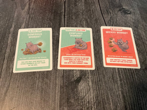 Generous wombat, confused wombat, and wicket wombat cards with transparent braille on them