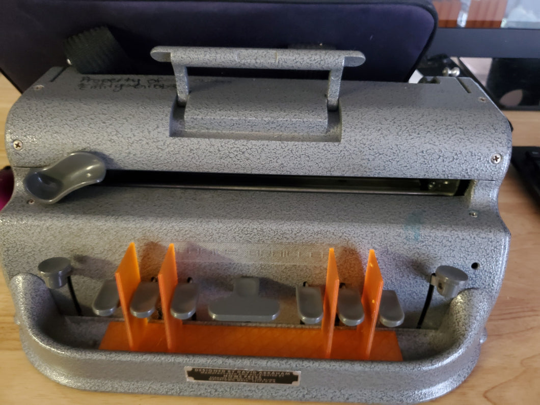 Picture is of a standard perkins brailler with an orange plastic divider between the keys