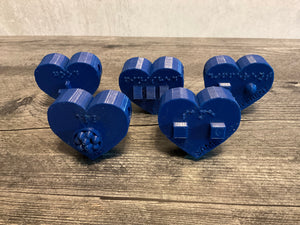 five blue heart shaped beads. Each has it's own symbol and braille as well as print Good Same Finished All Different