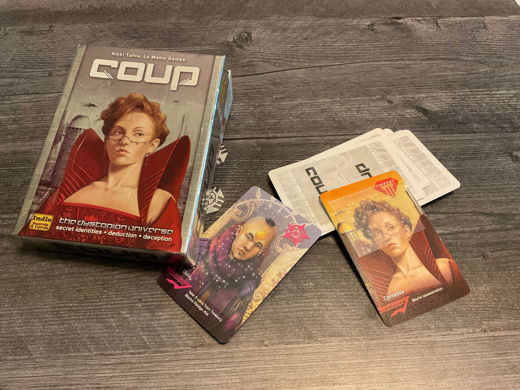 Coup box with two cards face up with braille stickers on them